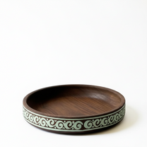Wooden bowl with decorative rim on a light gray background