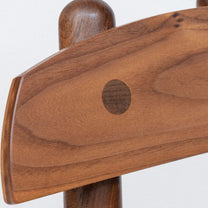 Close-up of a wooden chair armrest on a white background